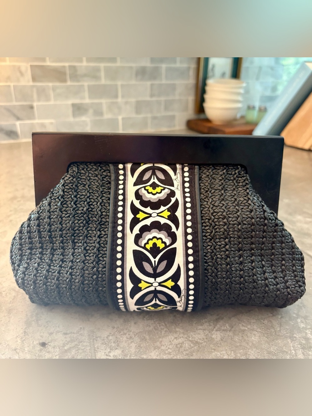 Vera Bradley black straw clutch Fanfare pattern featuring a wood frame handle